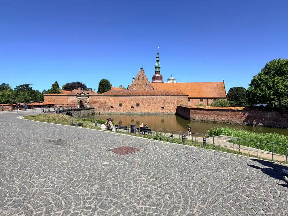 Brick fortress by water with moat and tower