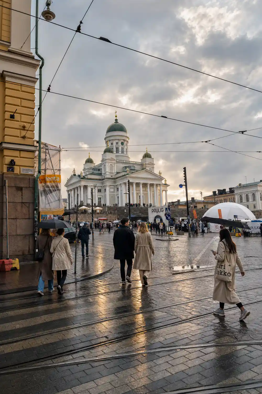 Cathedral with white dome in rainy city square with people