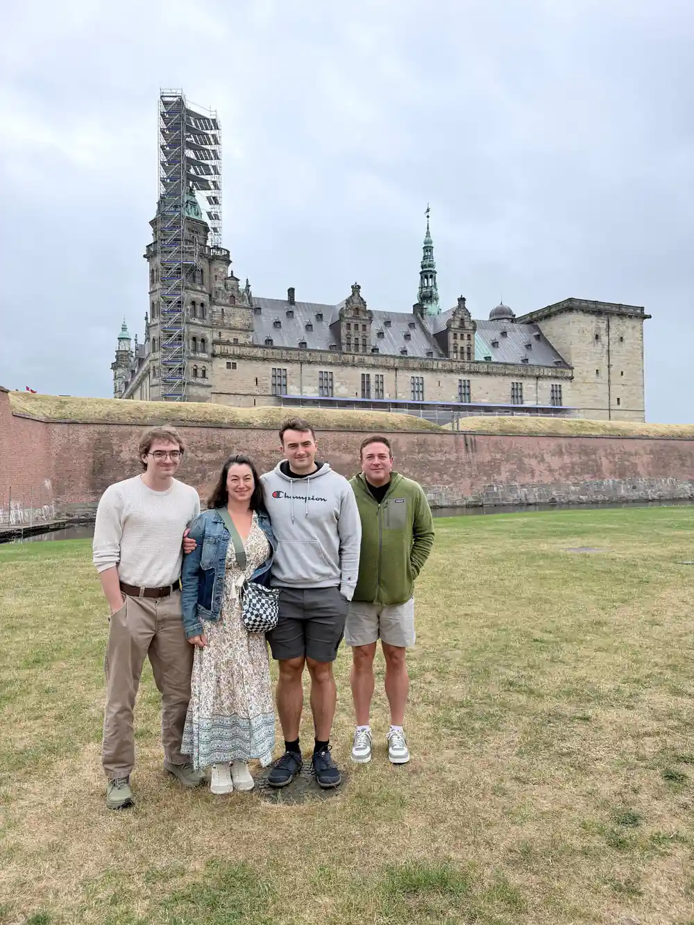 Four people standing before medieval fortress wall