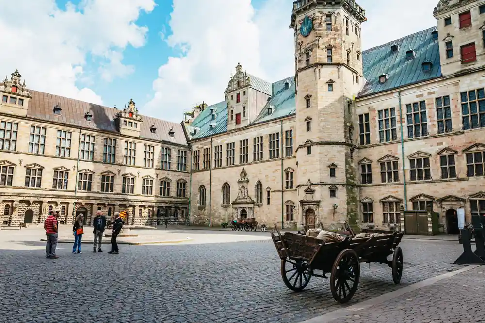 Historic castle courtyard with horse cart and people