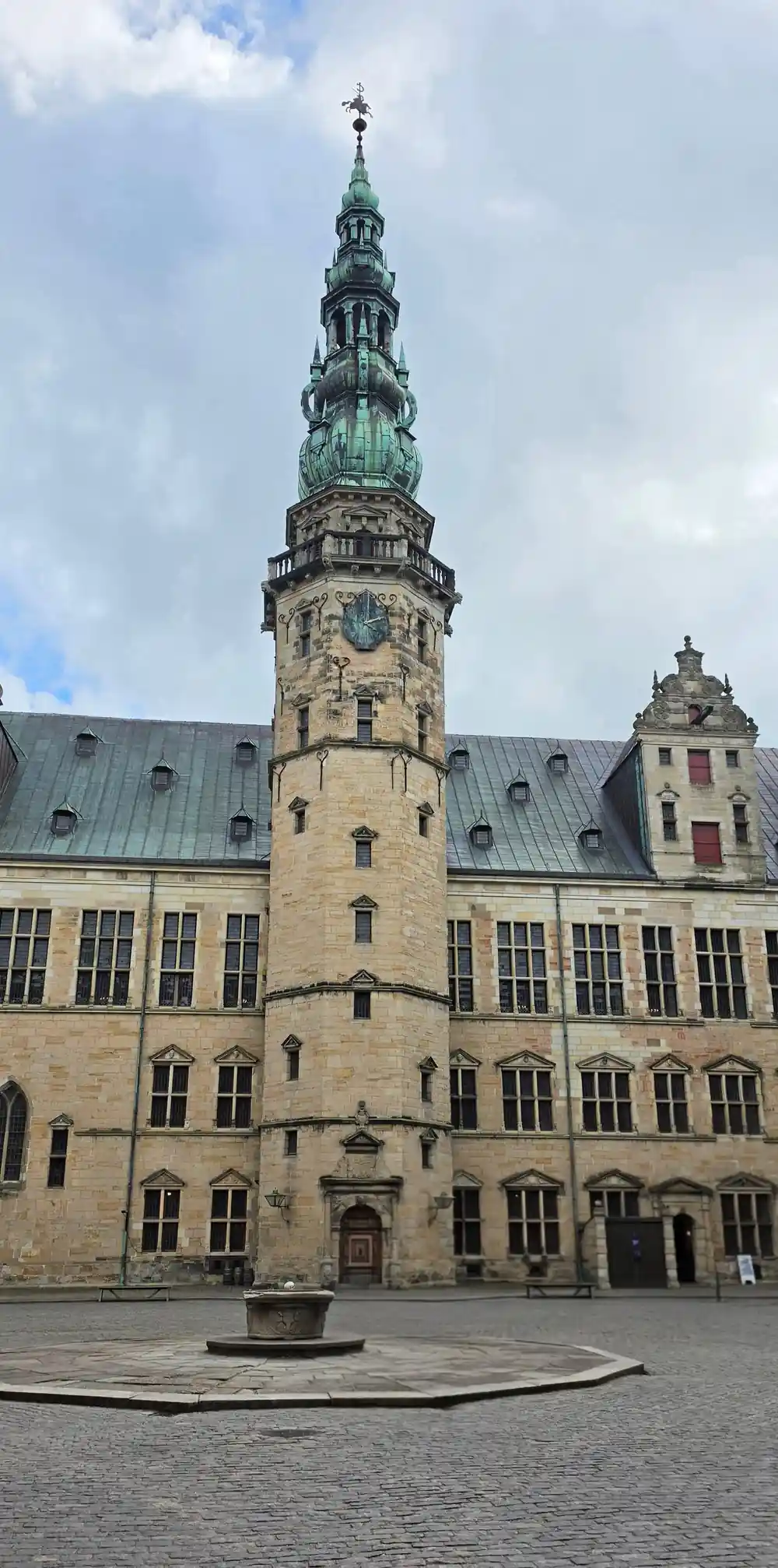 Historic stone building tower with green copper spire