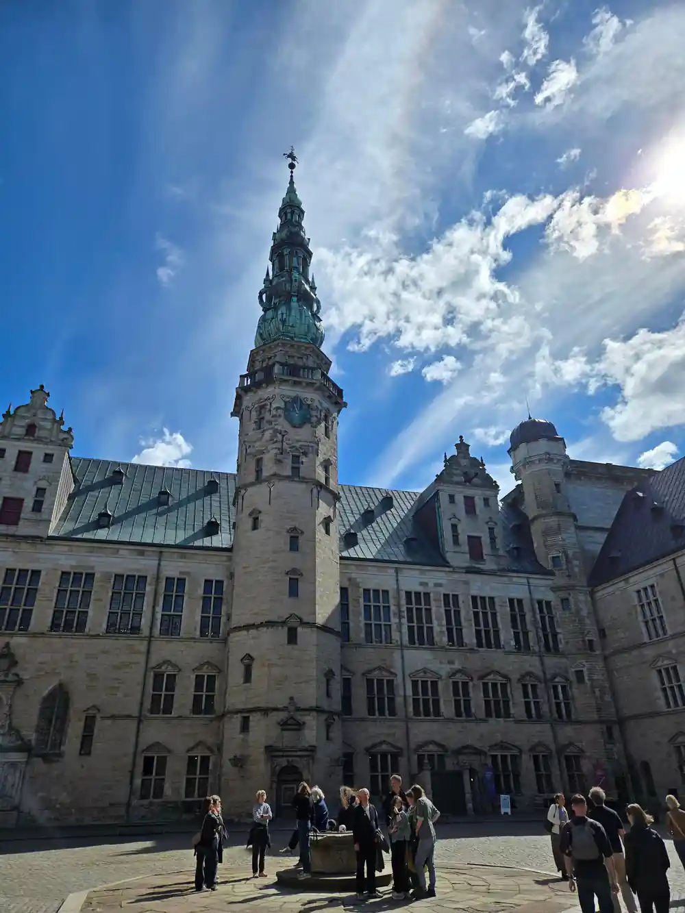 Medieval castle courtyard with tower and visitors