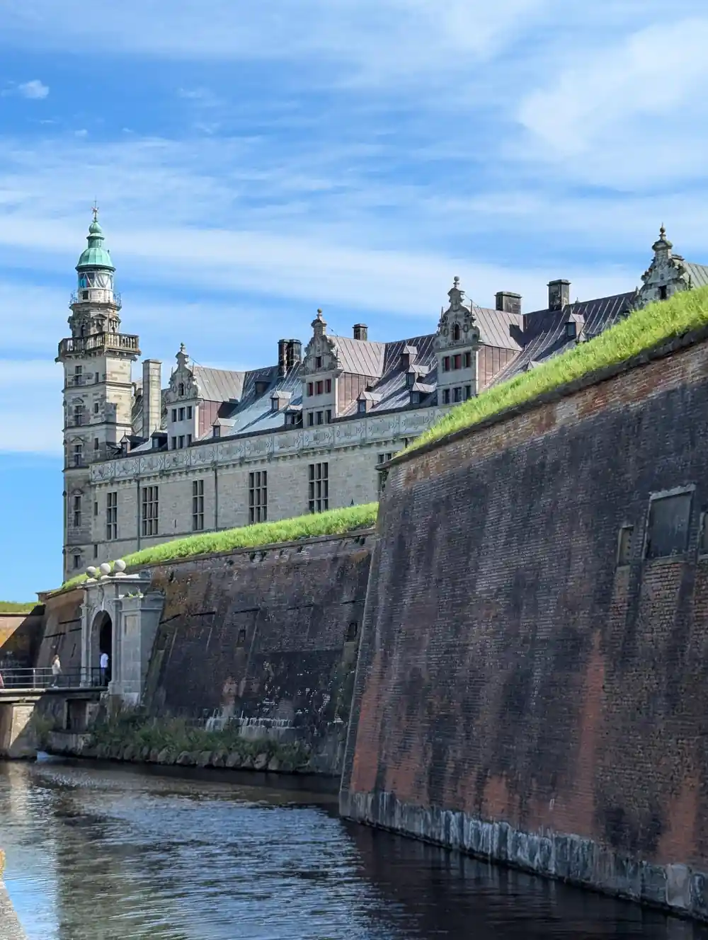 Medieval castle on green hillside overlooking waterway