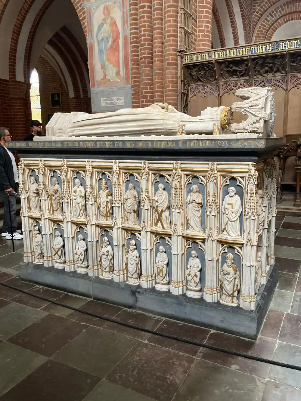 Ornate stone religious tomb with carved saints inside church