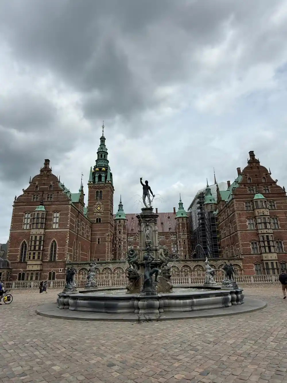 Red brick castle with central fountain in courtyard