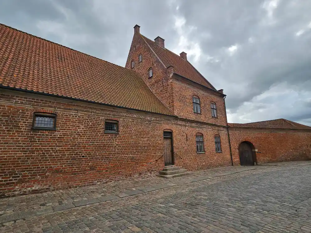Red brick historic building with courtyard and gate