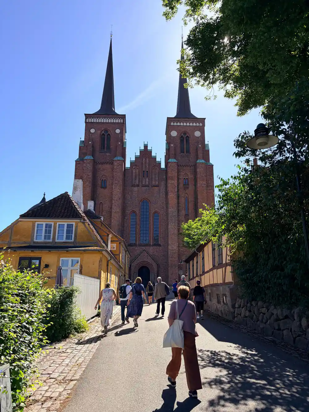 Red brick twin-spired church viewed from street