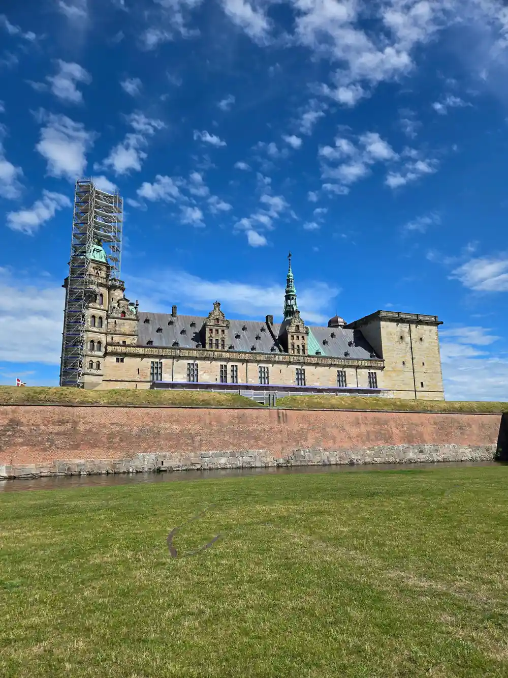 Renaissance castle with tower surrounded by green moat