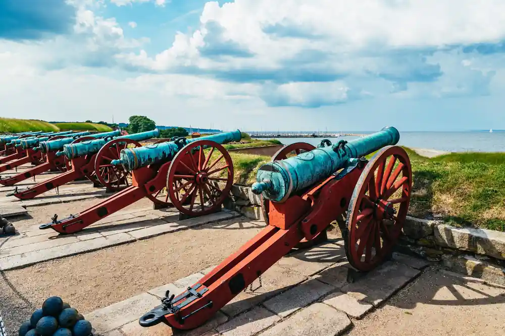 Row of blue and red historical cannons on grass